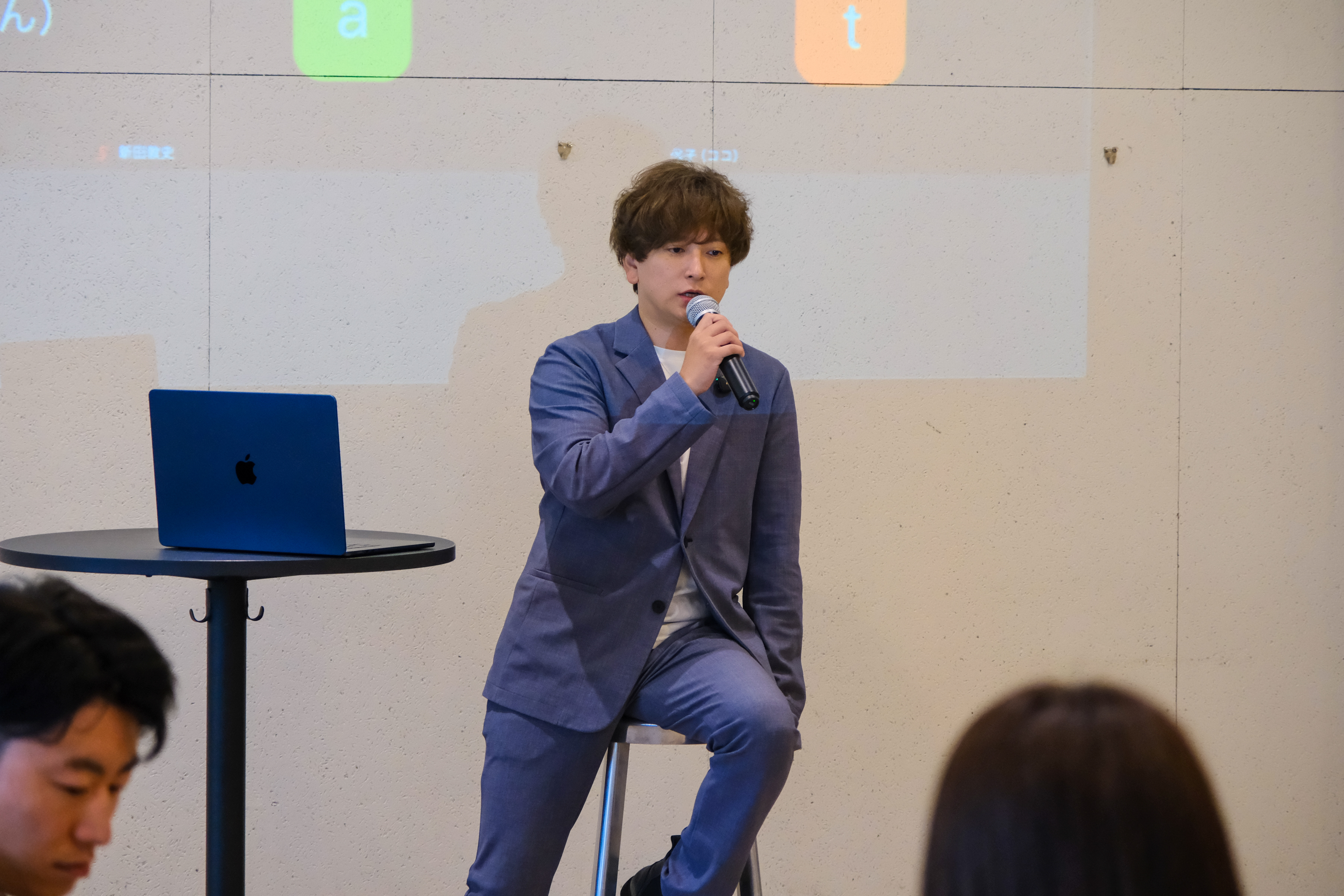 イベントでマイクを持って話す齋藤圭